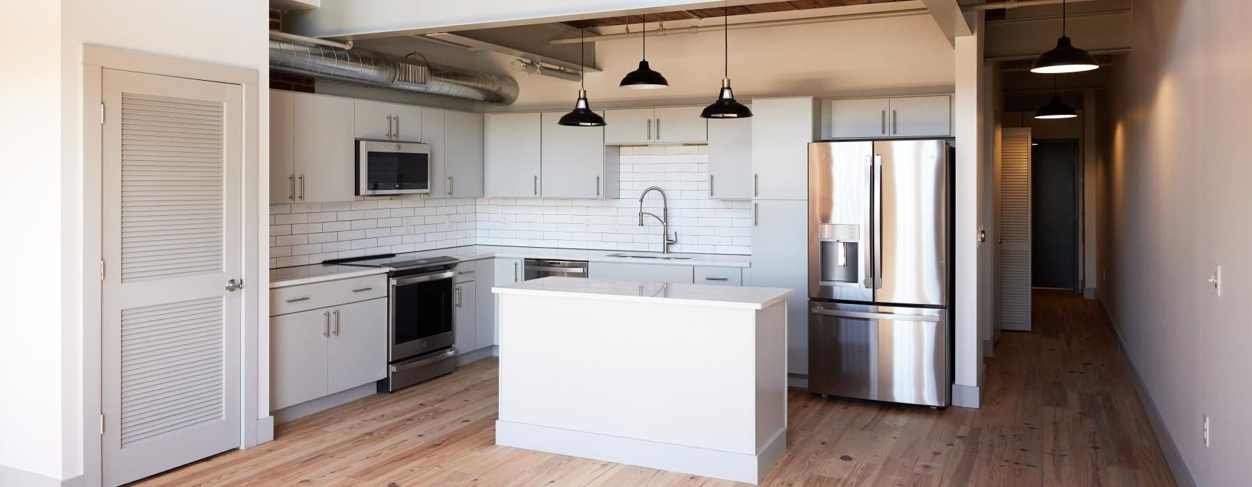 a kitchen with white cabinets and an island