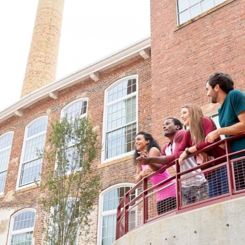 Find your perfect fit at 2005 at Revolution Mill Apartments a group of people on a balcony