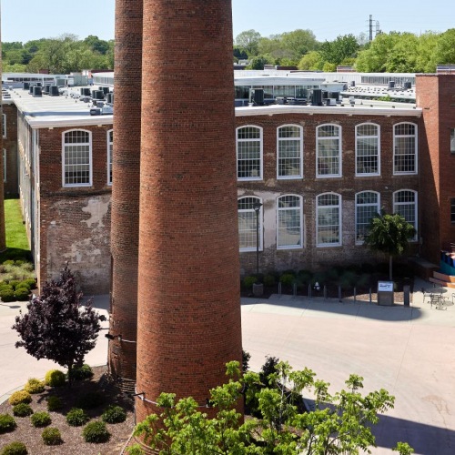 Find your perfect fit at 2005 at Revolution Mill Apartments a few tall smoke stacks in front of a building